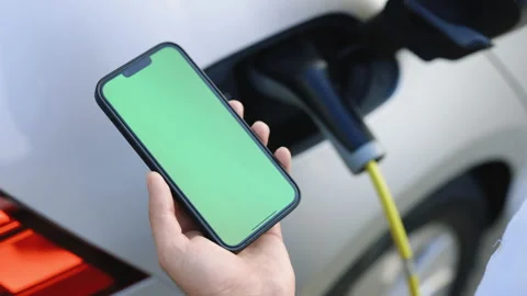 Green screen mock up chromakey display smart phone with electric car charging on Stock Footage 200974465