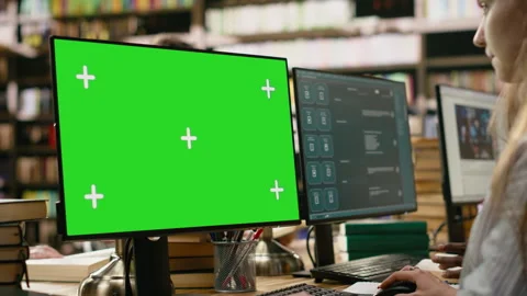Green screen mockup on computer desktop near student at shared library table 스톡 동영상 337231422