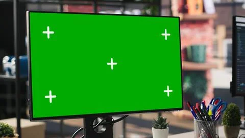 Green screen mockup computer in office next to displays showing data metrics Stock Photos