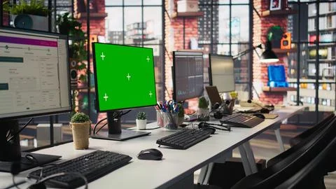 Green screen mockup computer in office next to displays showing data metrics 写真素材