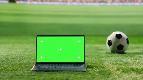 Green screen mockup on laptop placed on stadium grass pitch with soccer ball Stock Footage 337996225