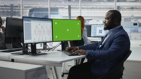 Green screen mockup PC used by man in semiconductors factory office Stock Photos