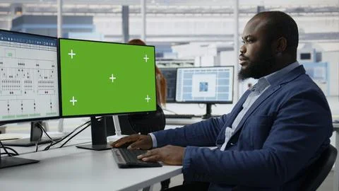 Green screen mockup PC used by man in semiconductors factory office Stock Photos