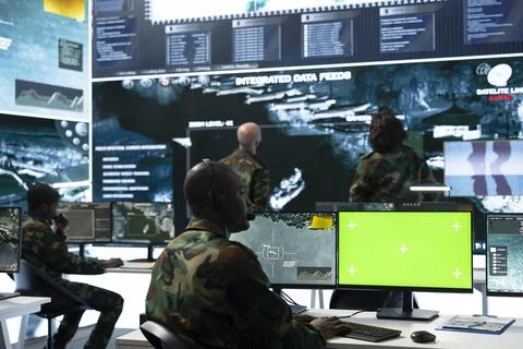 Green screen mockup PC used by army operator wearing audio headset Stock Photos