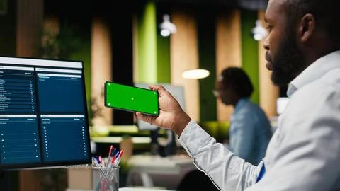 Green screen mockup screen on mobile phone held by a general manager Stock Photos