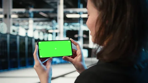 Green screen mockup smartphone used by server hub worker watching videos Stock Footage 329324048