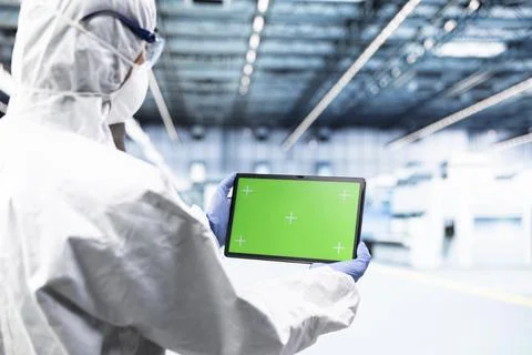 Green screen mockup tablet, using application and man in microchip plant Foto stock