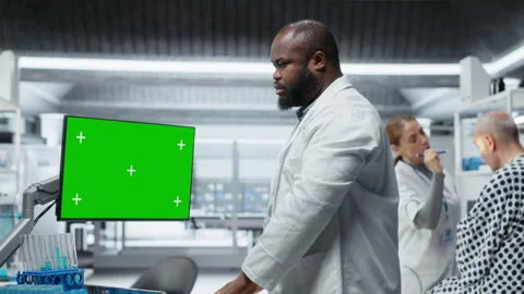 Green screen next to black medic studying data for drug testing in lab Stock Footage 319365116