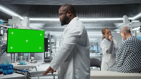 Green screen next to black medic studying data for drug testing in lab Stock Footage 319366777