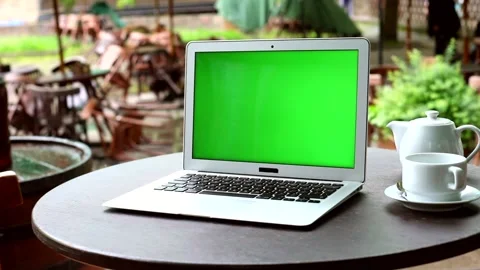 Green screen notebook on wooden table in outdoors cafe with modern exterior on b 스톡 동영상 131550198