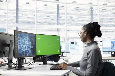 Green screen PC and AI in microchip factory RD office used by female technician Stock Photos