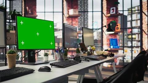 Green screen PC monitors in empty call center office, panning shot Stock Photos