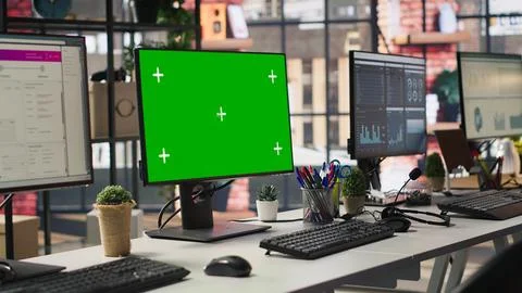 Green screen PC monitors in empty call center office, panning shot Stock Photos