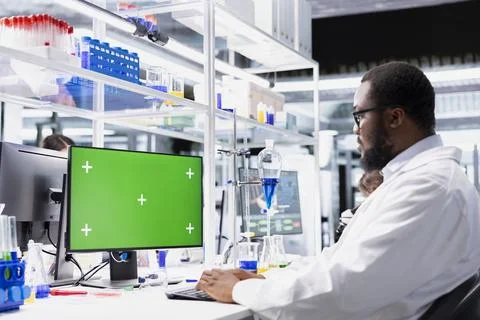 Green screen PC used by laboratory molecular biologist to process patient data 스톡 사진
