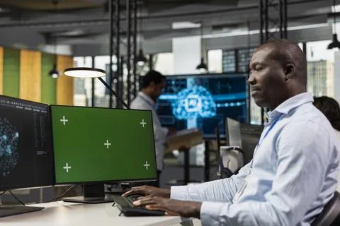Green screen PC used by programmer in startup company office testing AI 库存照片