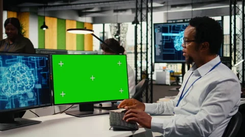 Green screen PC used by technician in startup office working with AI Stock Footage 322706065