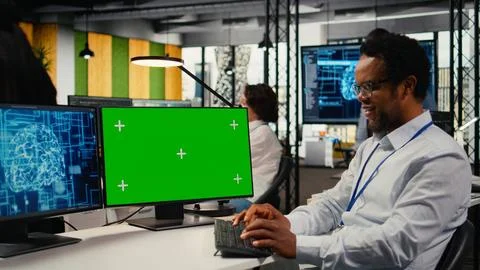 Green screen PC used by technician in startup office working with AI Stock Photos