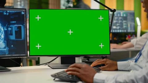Green screen PC used by technician in startup office working with AI Stock Photos