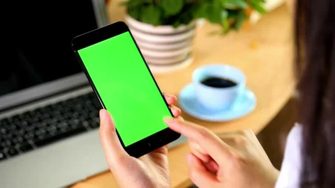 Green screen phone and human hand, woman has a green screen smart phone in cafe Video stock 336585701