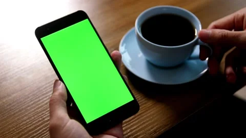 Green screen phone and human hand, woman has a green screen smart phone in cafe Video stock 336585732