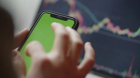 Green screen on phone, with cryptocurrency chart price on background. Smartphone Stock Footage 229168037