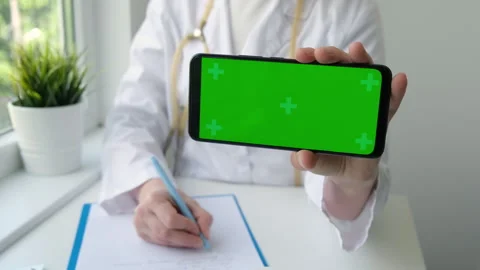 Green screen phone in horizontal position in doctor hand in medical clinic Video stock 244864479