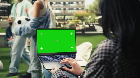 Green screen phone mockup held close to camera in outdoor campus setting Stock Footage 340810421