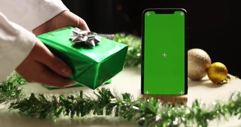 Green screen phone surrounded by festive Christmas gifts and decorations Stock Footage 339072191