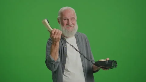 Green Screen. Portrait of an Old Man Showing How to Use a Vintage Telephone. Stock Footage 249705441