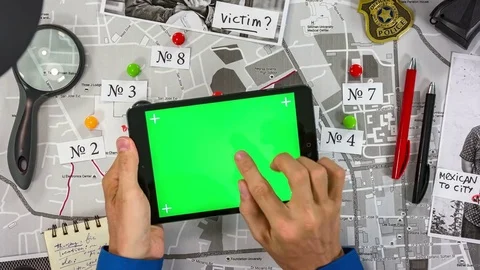 Green screen projection on the tablet. The detective flips through the pages. 스톡 동영상 80209745