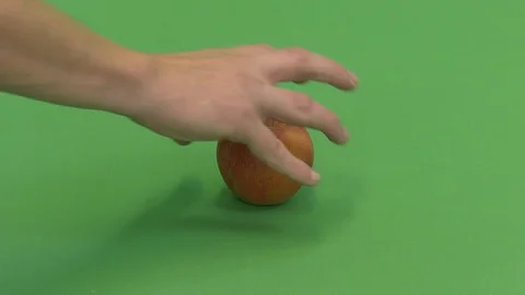 Green screen shot of a white man's hand picking up an apple Stock Footage 118129285