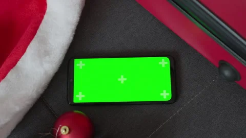 A green screen, smartphone and red suitcase create an enchanting atmosphere of Stock Footage 246806872