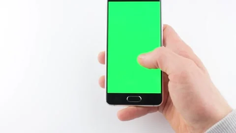 A green screen smartphone on a isolated a man holds in his hand chroma key Stock Footage 204088124