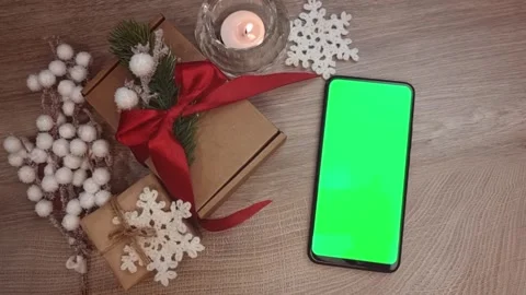 Green screen smartphone lying vertically on wooden table next to burning candle Stock Footage 291423087