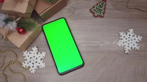 Green screen smartphone lying vertically on wooden table next to gifts and DIY Stock Footage 295068887
