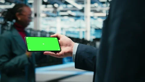 Green screen smartphone, managing wireframe mesh gear and admin in data center Stock Footage 329650908