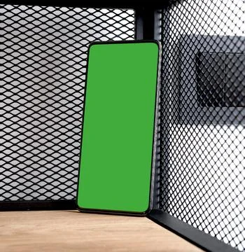 Green screen smartphone mockup tilted steeply in the corner of an industrial Stock Photos