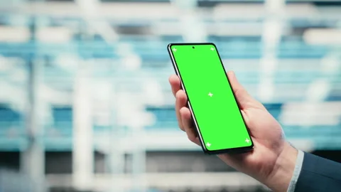 Green screen smartphone used by data center admin managing wireframe mesh gear Stock Footage 329531398