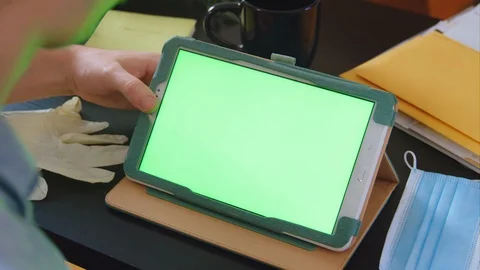 A green screen tablet being watched over the shoulder - slow motion Stock Footage 129960832