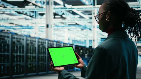 Green screen tablet in data center and augmented reality used by developer Stock Footage 329532237