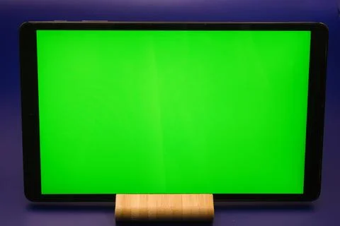Green screen on a tablet device set against a blue background for creative .. Stock Photos