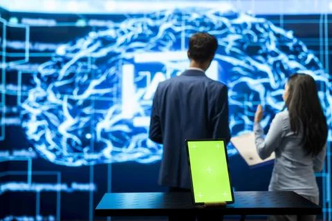Green screen tablet in front of tech startup colleagues reviewing AI Stock Photos