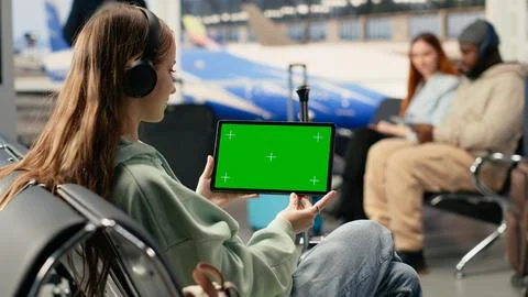Green screen tablet held by digital nomad girl using airport internet Stockfoto's