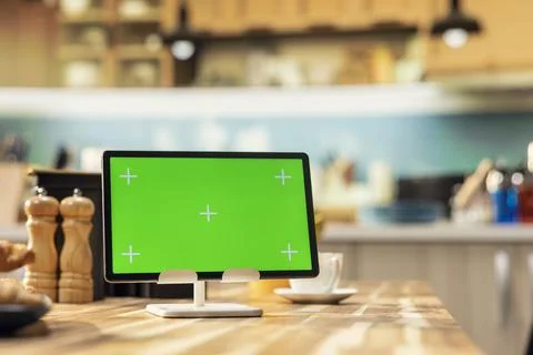 Green screen on tablet in kitchen interior design with empty wooden table Stock Photos