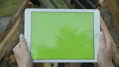 Green screen tablet landscape view at camp site with fire in background, 4k Stock Footage 112764146