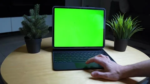 Green screen tablet mockup on desk, hand using keyboard case in dark office Stock Footage 328963921