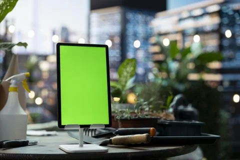 Green screen tablet mockup on stand in urban rooftop garden workspace Stock Photos