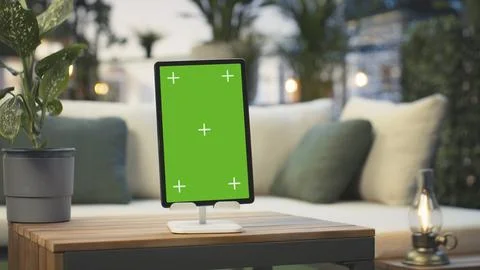 Green screen tablet on rooftop table with leafy plants, close up Stock Photos