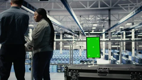 Green screen tablet in server room in front of admins optimizing AI systems Stock Footage 314684088