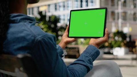 Green screen on tablet shown by african american girl relaxing in park downtown Stock Photos